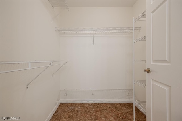 walk in closet with tile flooring