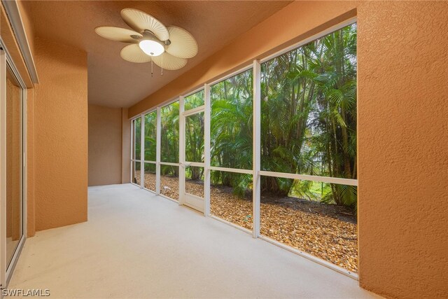 unfurnished sunroom with ceiling fan