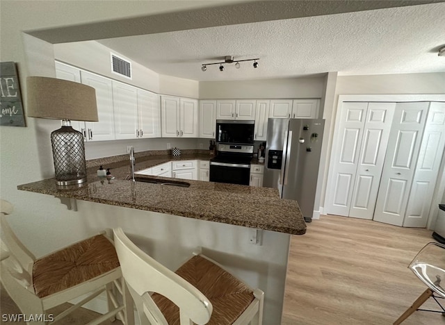 kitchen with a kitchen bar, kitchen peninsula, and stainless steel appliances