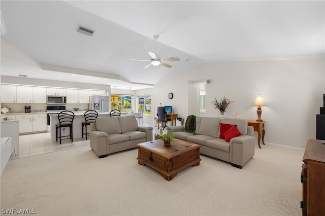 living room featuring ceiling fan, vaulted ceiling, and light colored carpet