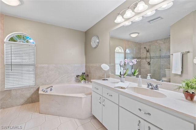 bathroom with tile flooring, vanity, and plus walk in shower