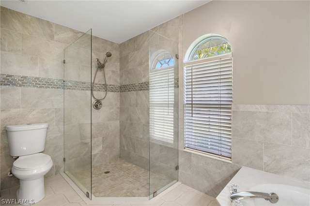 bathroom featuring tile walls, tile floors, shower with separate bathtub, and toilet