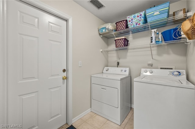 clothes washing area featuring electric dryer hookup, hookup for a washing machine, washer and clothes dryer, and light tile flooring