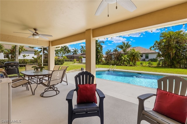 view of pool with area for grilling, a patio, a lawn, and ceiling fan