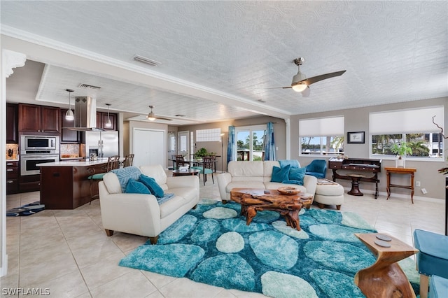 living area with visible vents, ceiling fan, a textured ceiling, and light tile patterned flooring