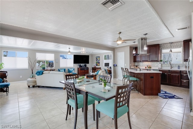 dining room with light tile patterned floors, plenty of natural light, visible vents, and ceiling fan