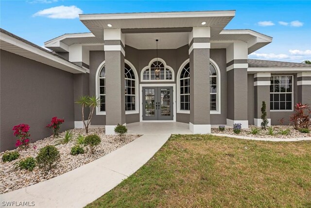 entrance to property with a lawn and french doors