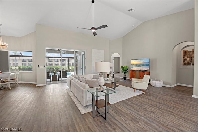 living room with dark hardwood / wood-style flooring, high vaulted ceiling, and ceiling fan with notable chandelier