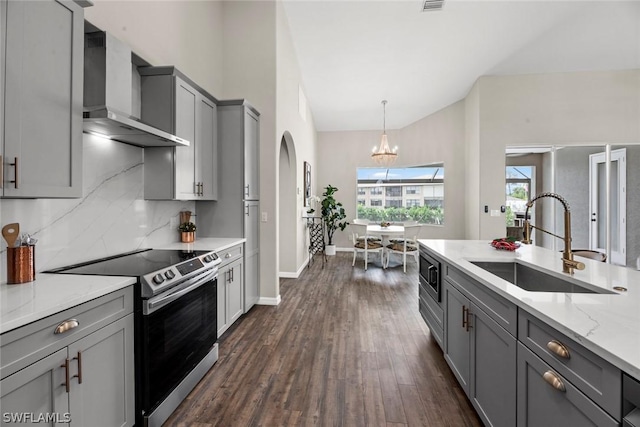 kitchen featuring gray cabinetry, sink, stainless steel appliances, wall chimney range hood, and dark hardwood / wood-style floors