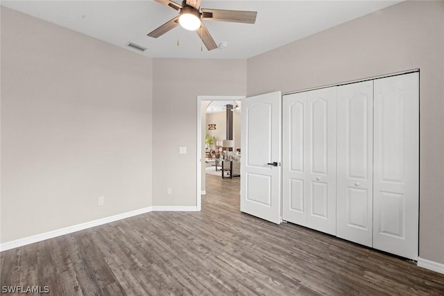 unfurnished bedroom featuring a closet, hardwood / wood-style flooring, and ceiling fan