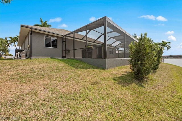 back of house featuring a lanai and a lawn