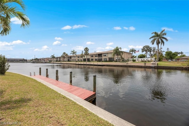 view of dock with a water view and a lawn