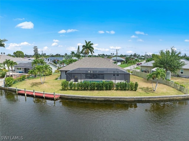 rear view of property with a water view, a yard, and glass enclosure