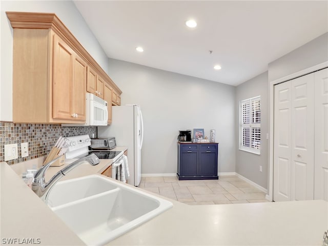 kitchen with light brown cabinets, sink, vaulted ceiling, white appliances, and light tile patterned flooring