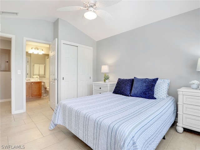 tiled bedroom featuring electric panel, vaulted ceiling, ceiling fan, connected bathroom, and a closet