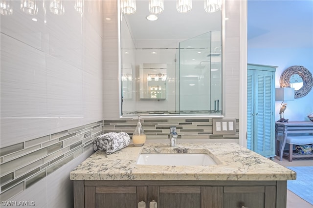 bathroom with backsplash, vanity, and an enclosed shower