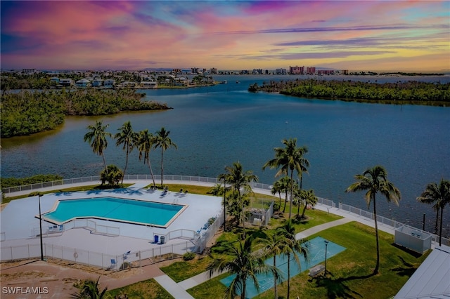 pool at dusk featuring a water view and cooling unit