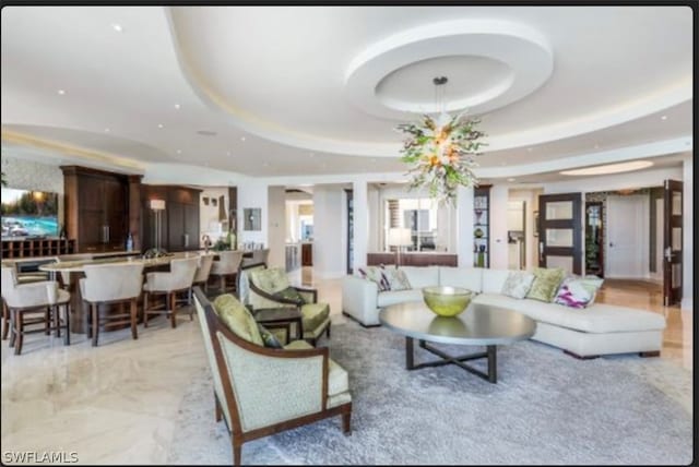 living room featuring a raised ceiling and light tile floors