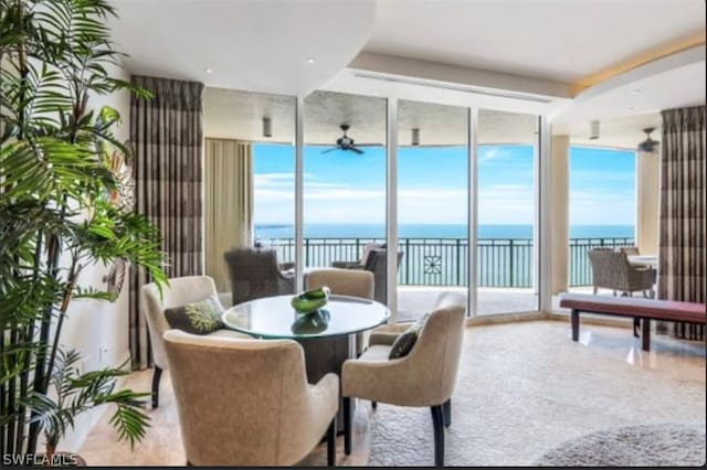 dining space featuring ceiling fan and a water view