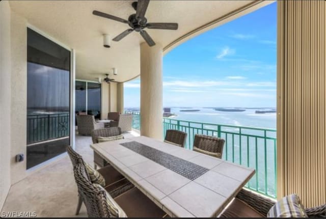 exterior space featuring ceiling fan and a water view