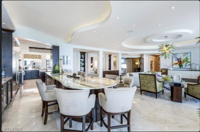 dining area with a tray ceiling and light tile floors