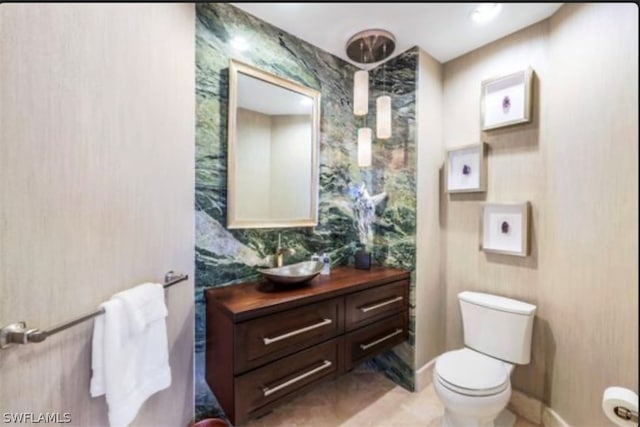 bathroom with tile flooring, vanity, and toilet