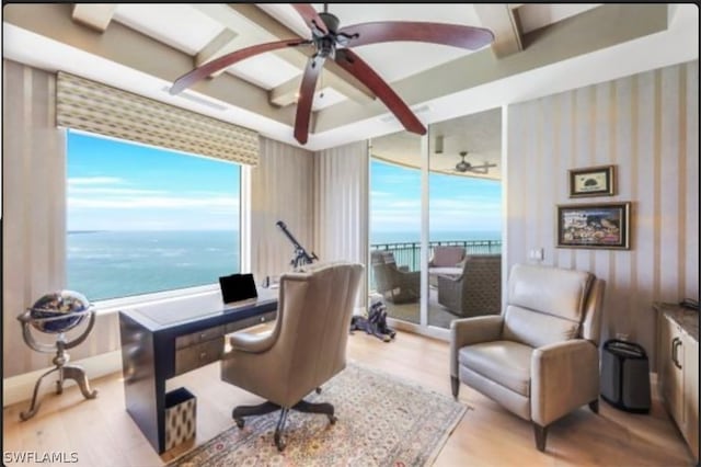 office featuring light wood-type flooring, a water view, and ceiling fan