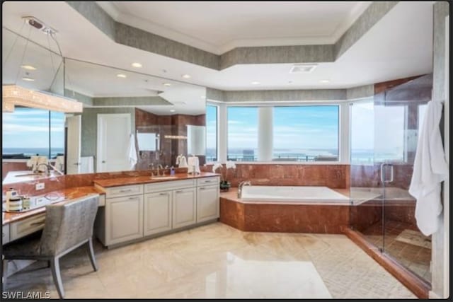 bathroom featuring tile flooring, a water view, a raised ceiling, plus walk in shower, and vanity