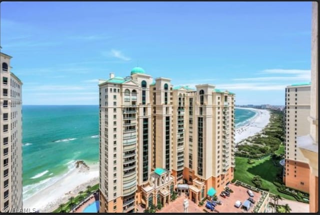 view of building exterior featuring a water view and a view of the beach