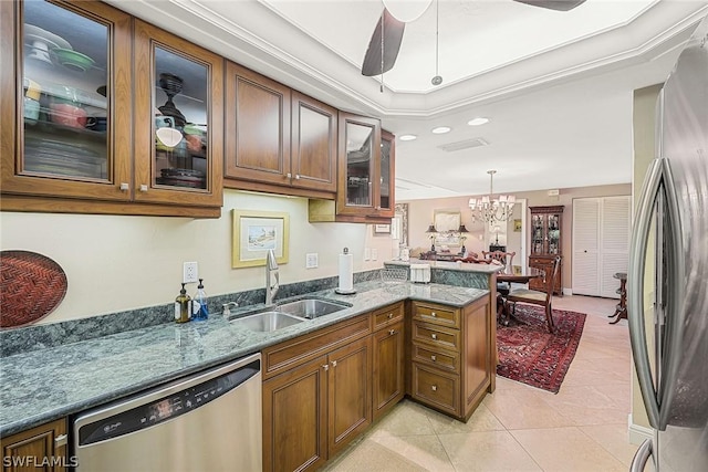 kitchen with light tile patterned flooring, pendant lighting, sink, kitchen peninsula, and stainless steel appliances