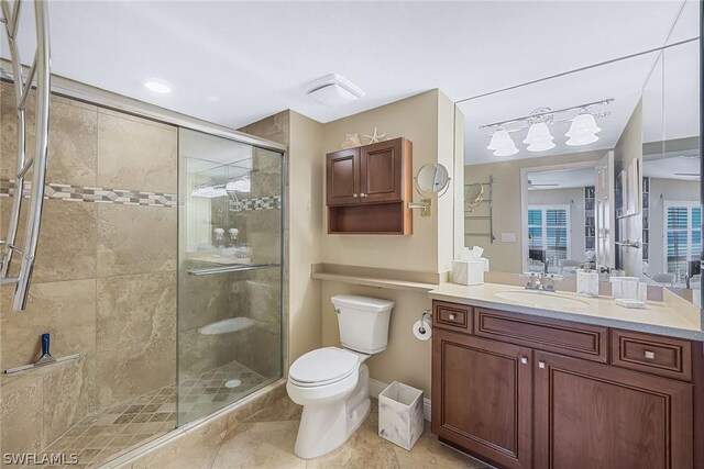 bathroom with a shower with shower door, tile flooring, oversized vanity, and toilet