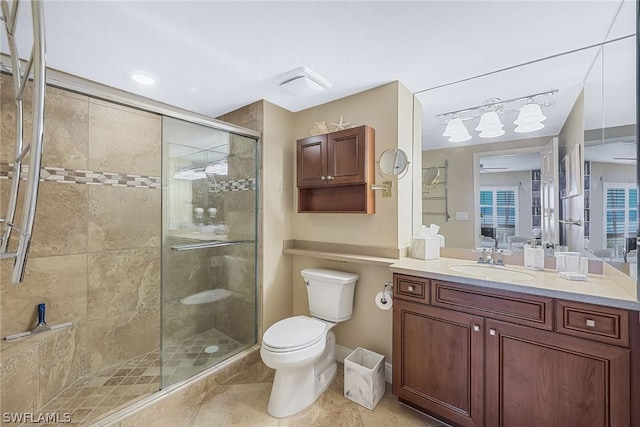 bathroom with tile patterned floors, vanity, toilet, and a shower with shower door