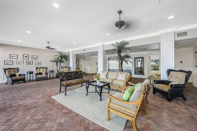 living room with ceiling fan, crown molding, and ornate columns