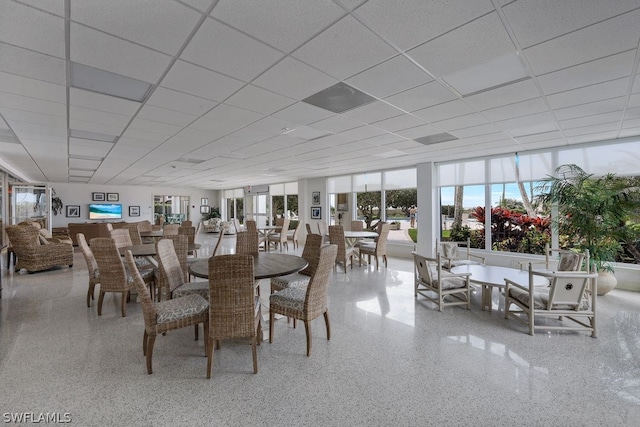 unfurnished dining area with a drop ceiling