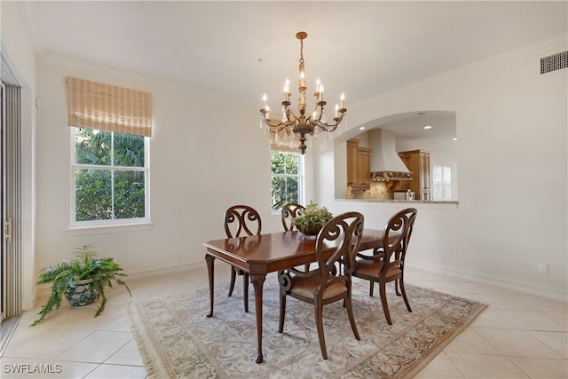 tiled dining room with a notable chandelier and crown molding