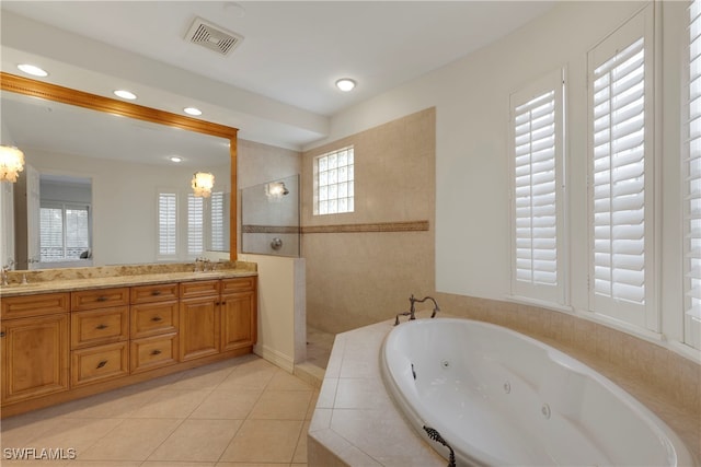 bathroom with tile patterned flooring, shower with separate bathtub, vanity, and a notable chandelier