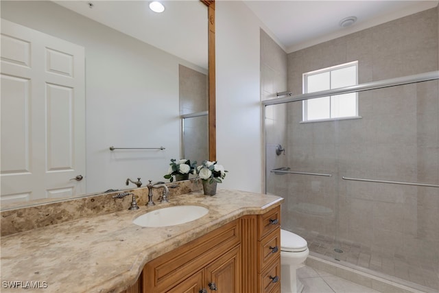 bathroom featuring tile patterned flooring, vanity, toilet, and a shower with shower door