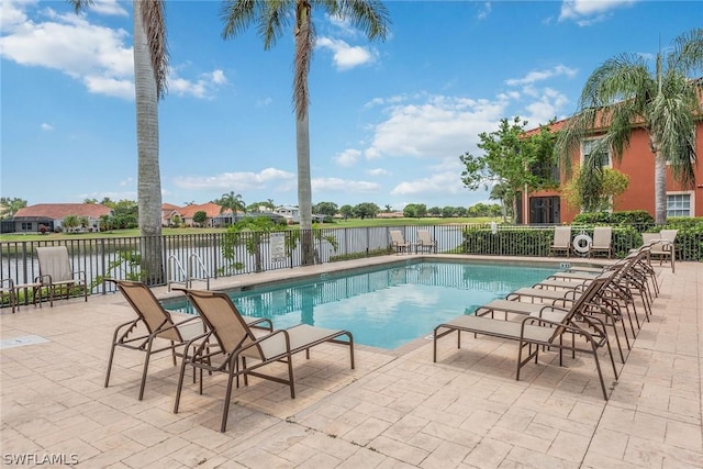 view of swimming pool with a patio and a water view