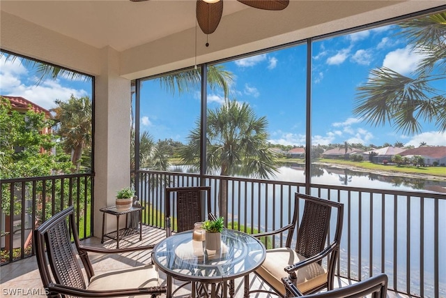 sunroom / solarium featuring ceiling fan and a water view