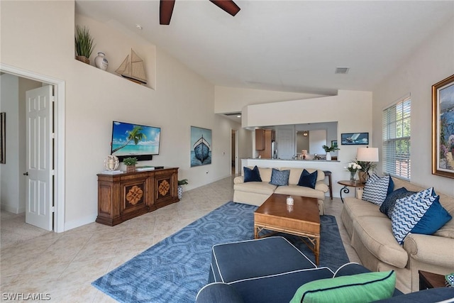 living room with ceiling fan, lofted ceiling, and light tile patterned flooring