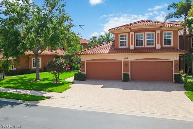 mediterranean / spanish home featuring a front lawn and a garage