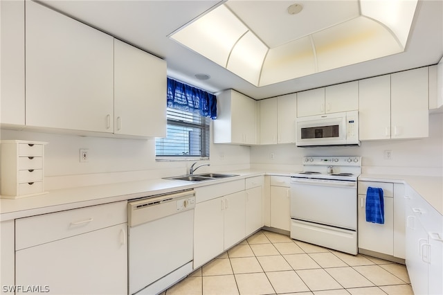 kitchen featuring sink, white cabinetry, white appliances, and light tile flooring