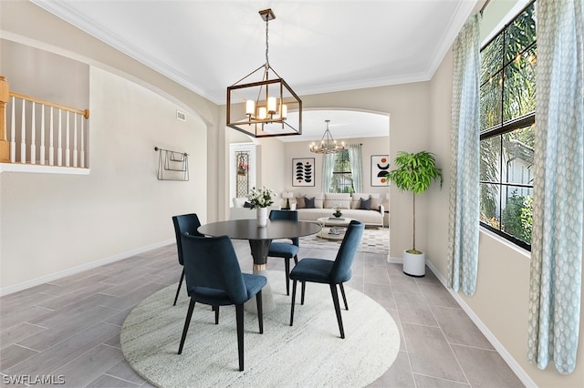 dining space featuring arched walkways, visible vents, baseboards, ornamental molding, and an inviting chandelier