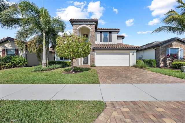 mediterranean / spanish house featuring a front yard, decorative driveway, a tile roof, and stucco siding