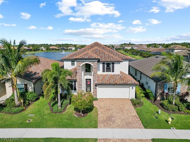 mediterranean / spanish-style house featuring a water view, a garage, and a front yard