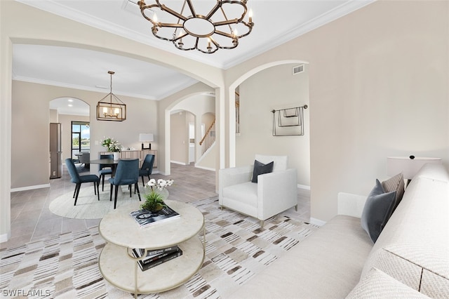 living area with baseboards, ornamental molding, visible vents, and a notable chandelier