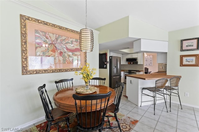 dining room featuring light tile patterned floors, sink, and vaulted ceiling