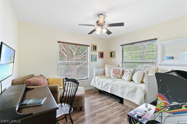 bedroom with multiple windows, ceiling fan, and wood-type flooring