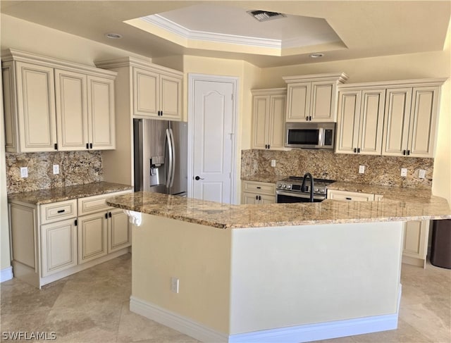 kitchen featuring a raised ceiling, stainless steel appliances, light stone counters, and tasteful backsplash