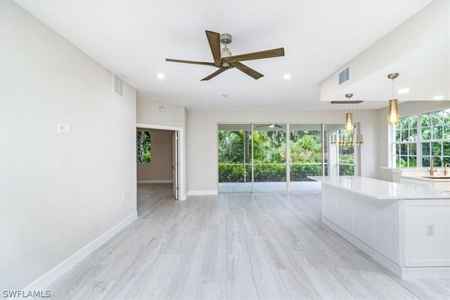 interior space with ceiling fan, light wood-type flooring, plenty of natural light, and sink